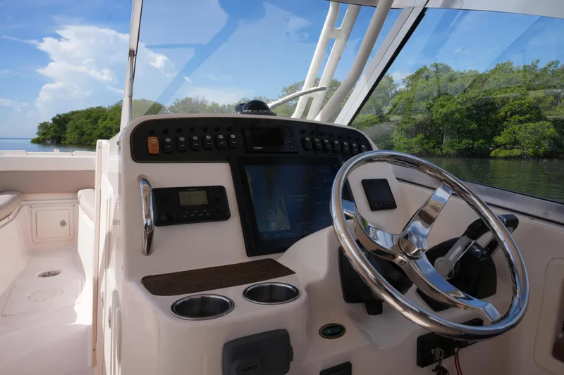 Slide: The Image of 2014 Grady-White Freedom 307 boat cockpit with steering wheel and control panel. - 13