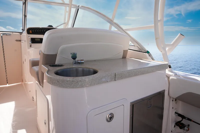 Slide: The Image of 2014 Grady-White Freedom 307 boat interior with sink and seating, ocean view. - 22