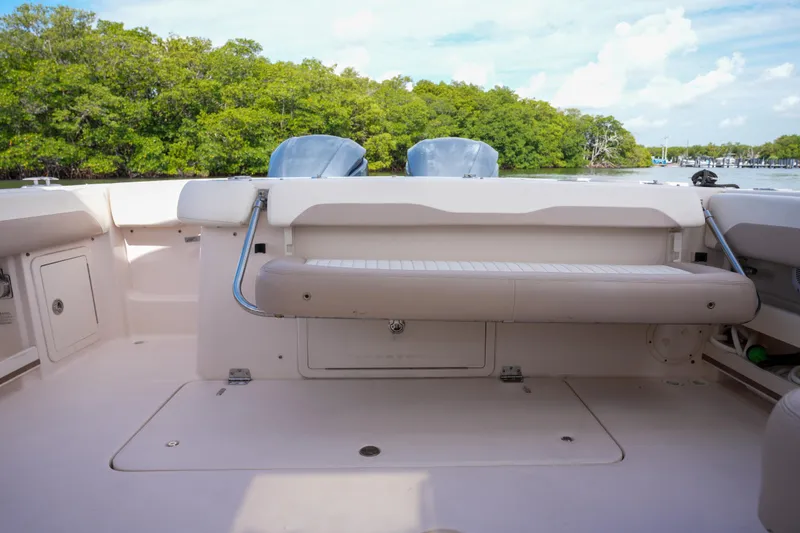 Slide: The Image of 2014 Grady-White Freedom 307 boat interior with seating, near lush greenery and calm waters. - 27