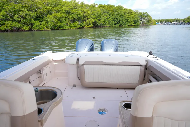 Slide: The Image of 2014 Grady-White Freedom 307 boat interior with dual engines on a calm waterway. - 29