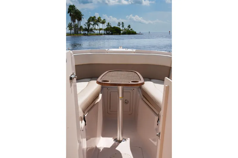 Slide: The Image of 2014 Grady-White Freedom 307 boat interior with table, overlooking serene water and palm trees. - 39
