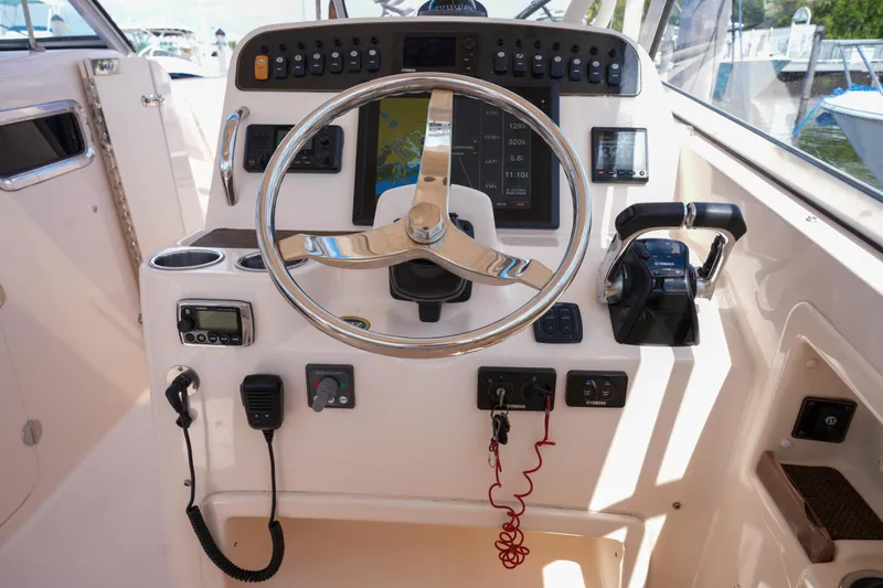Slide: The Image of 2014 Grady-White Freedom 307 boat dashboard with steering wheel and control panel. - 48