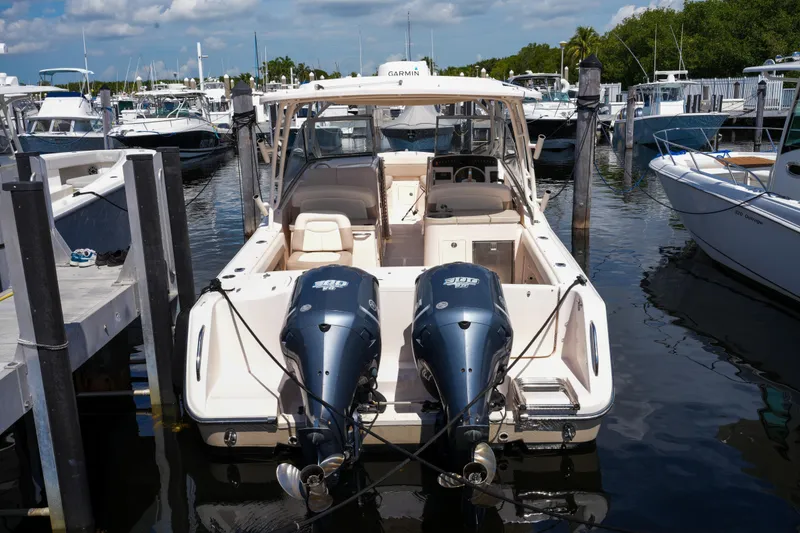 Slide: The Image of 2014 Grady-White Freedom 307 boat docked in a marina, featuring dual engines. - 51