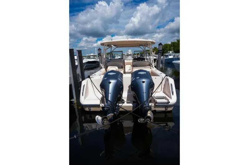 Slide: The Image of 2014 Grady-White Freedom 307 boat docked with twin outboard engines under a cloudy sky. - 52