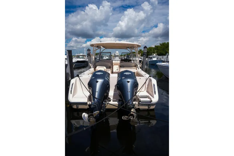 Slide: The Image of 2014 Grady-White Freedom 307 boat docked with twin outboard engines under a cloudy sky. - 53