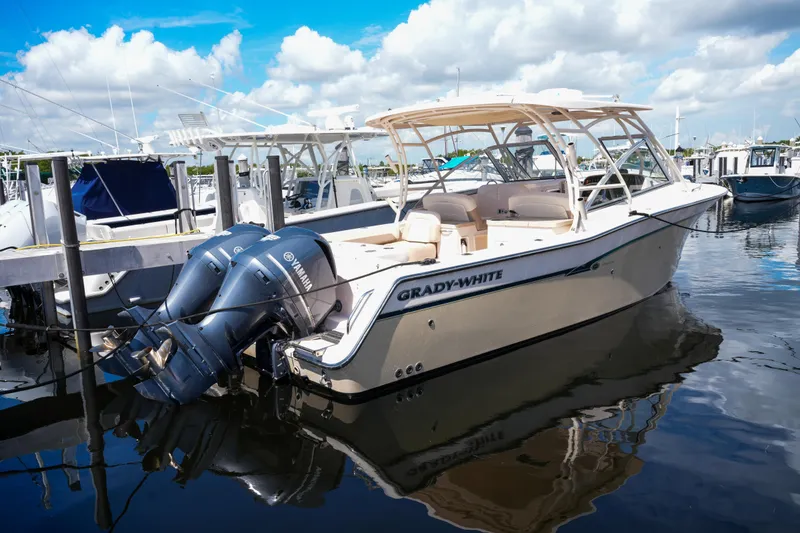 Slide: The Image of 2014 Grady-White Freedom 307 boat docked with twin Yamaha engines, under a blue sky. - 54