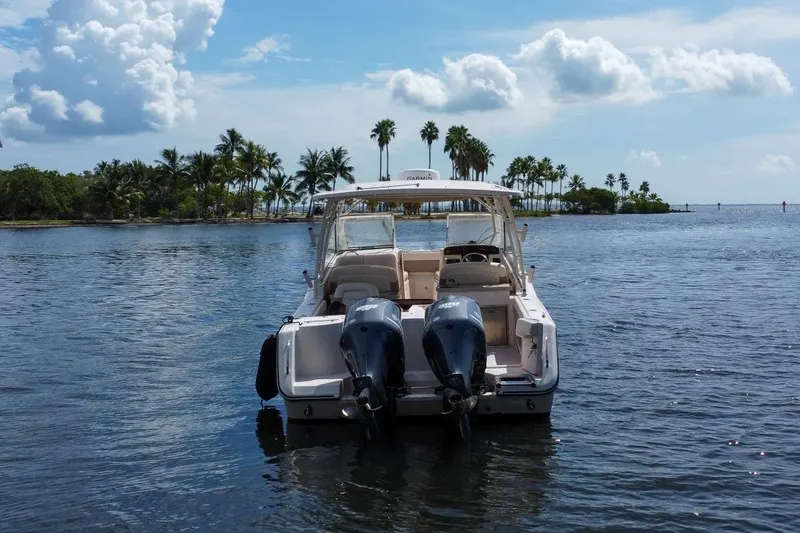 Slide: The Image of 2014 Grady-White Freedom 307 boat on water with palm trees in background. - 56