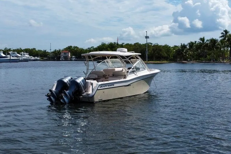 Slide: The Image of 2014 Grady-White Freedom 307 boat on calm water, with twin outboard engines. - 57