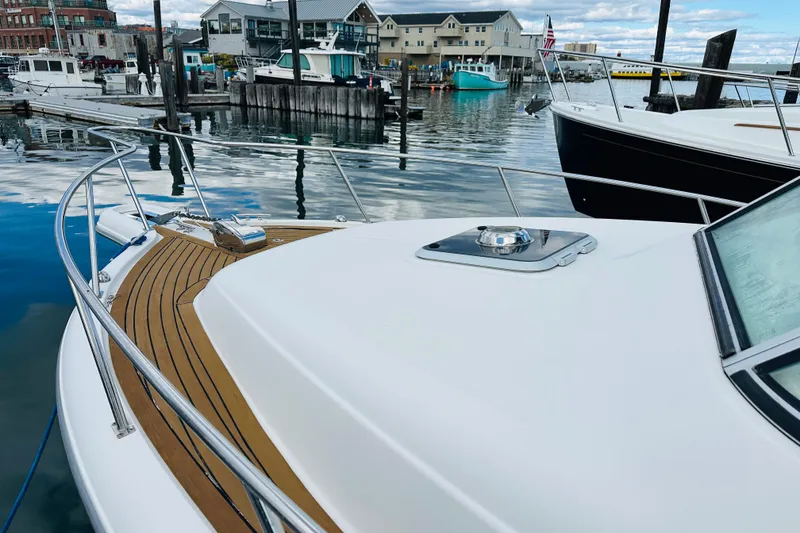 Slide: The Image of 2007 Pursuit OS 285 Offshore boat docked in a marina, showcasing sleek design and wood accents. - 10