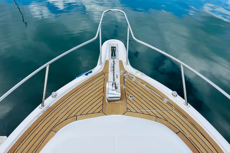 Slide: The Image of Bow of 2007 Pursuit OS 285 Offshore boat with teak decking on calm water. - 12