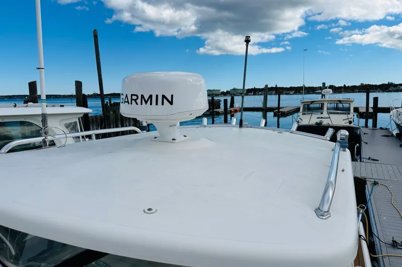 Slide: The Image of 2007 Pursuit OS 285 Offshore boat with Garmin radar, docked at a marina under blue skies. - 13
