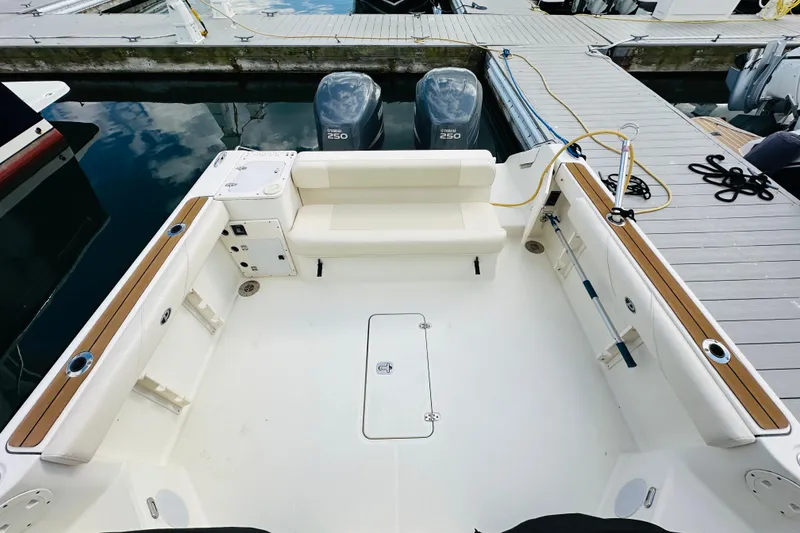 Slide: The Image of 2007 Pursuit OS 285 Offshore boat interior with seating and twin engines at dock. - 14