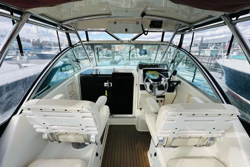 Slide: The Image of 2007 Pursuit OS 285 Offshore boat interior with helm, seats, and marina view. - 15