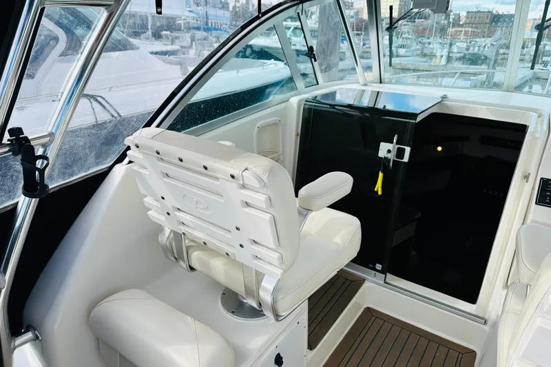 Slide: The Image of 2007 Pursuit OS 285 Offshore boat interior with helm seat and cabin door. - 16