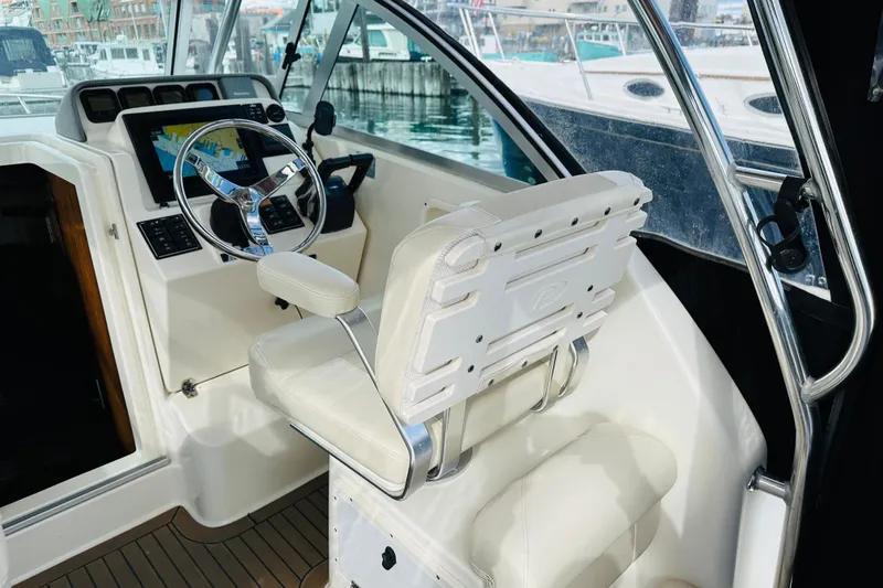 Slide: The Image of 2007 Pursuit OS 285 Offshore boat cockpit with steering wheel and navigation display. - 17