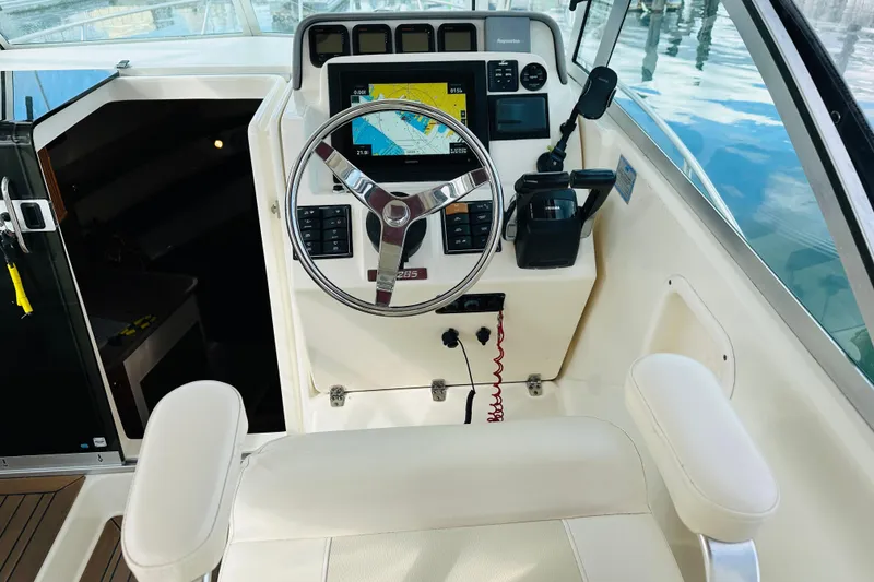Slide: The Image of 2007 Pursuit OS 285 Offshore boat helm with steering wheel and navigation display. - 18