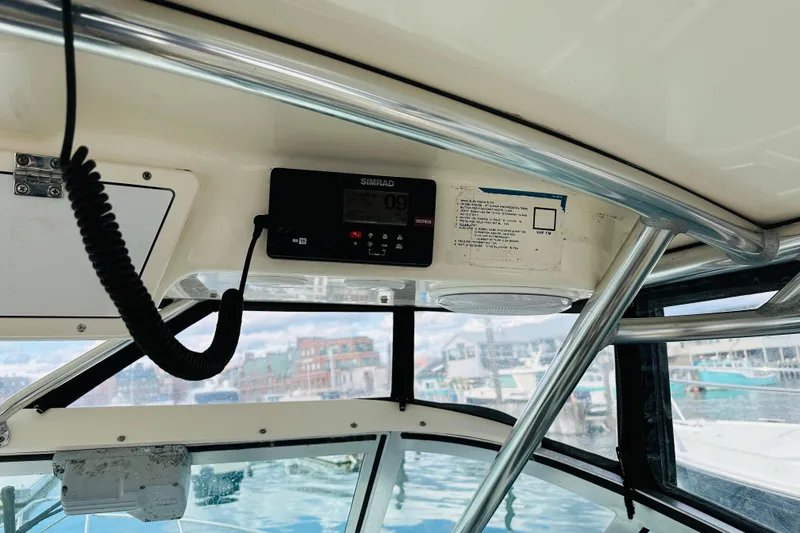 Slide: The Image of 2007 Pursuit OS 285 Offshore boat interior with radio and marina view. - 22