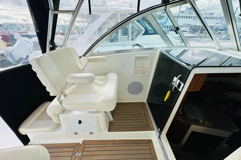 Slide: The Image of 2007 Pursuit OS 285 Offshore boat interior with white seating and wooden flooring. - 24