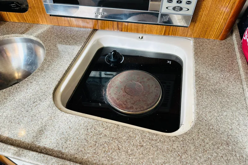 Slide: The Image of 2007 Pursuit OS 285 Offshore boat kitchen with stove and sink. - 29