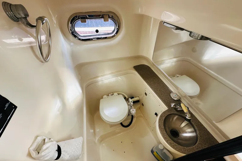Slide: The Image of 2007 Pursuit OS 285 Offshore boat bathroom with sink, toilet, and porthole window. - 34