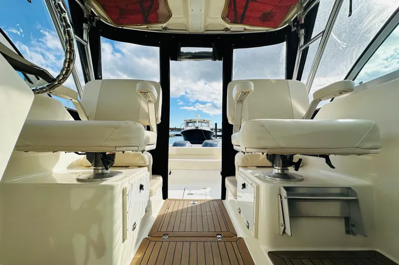 Slide: The Image of 2007 Pursuit OS 285 Offshore boat interior with white seats and wooden flooring. - 35