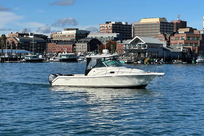 Slide: The Image of 2007 Pursuit OS 285 Offshore boat cruising in a scenic harbor with city skyline. - 38