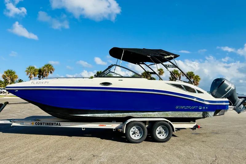The Image of 2015 Starcraft Crossover 250 SCX OB boat on trailer under blue sky. - 0