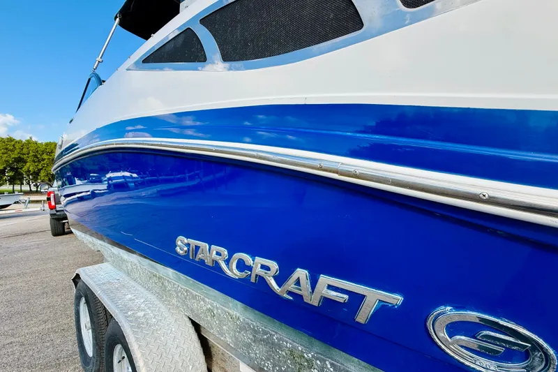 Slide: The Image of 2015 Starcraft Crossover 250 SCX OB boat on trailer, close-up view. - 10