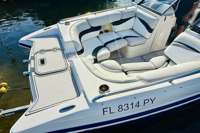Slide: The Image of 2015 Starcraft Crossover 250 SCX OB boat with white and black seating on water. - 13