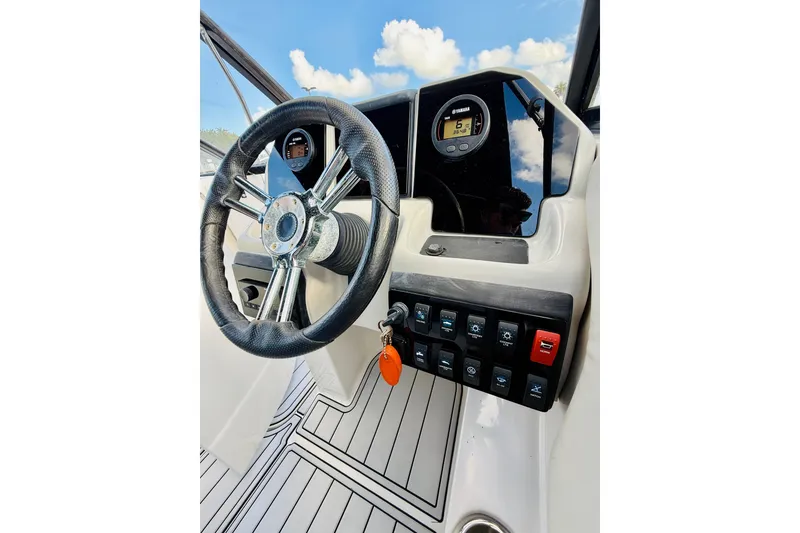 Slide: The Image of 2015 Starcraft Crossover 250 SCX OB boat dashboard with steering wheel and control panel. - 22
