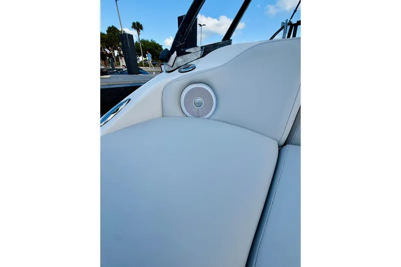 Slide: The Image of 2015 Starcraft Crossover 250 SCX OB boat interior with speaker and cushioned seating. - 27