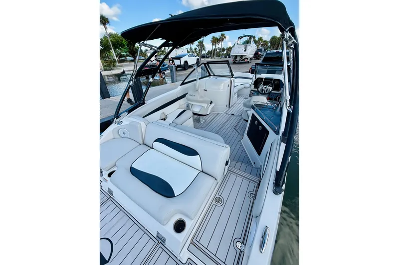 Slide: The Image of 2015 Starcraft Crossover 250 SCX OB boat interior with seating and helm, docked by water. - 31