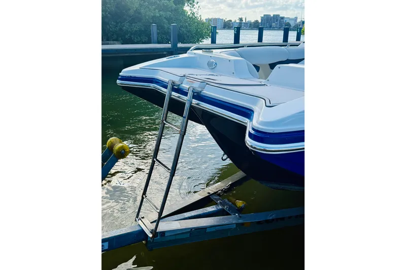 Slide: The Image of 2015 Starcraft Crossover 250 SCX OB boat on trailer with ladder, docked by water. - 33