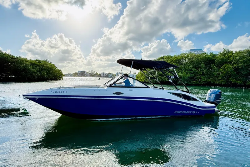 Slide: The Image of 2015 Starcraft Crossover 250 SCX OB boat on calm water under a cloudy sky. - 34
