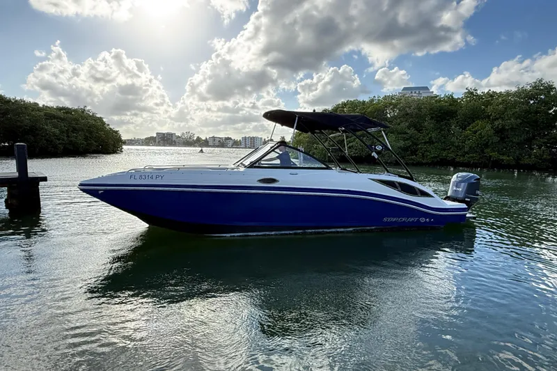 Slide: The Image of 2015 Starcraft Crossover 250 SCX OB boat on calm water under cloudy sky. - 35