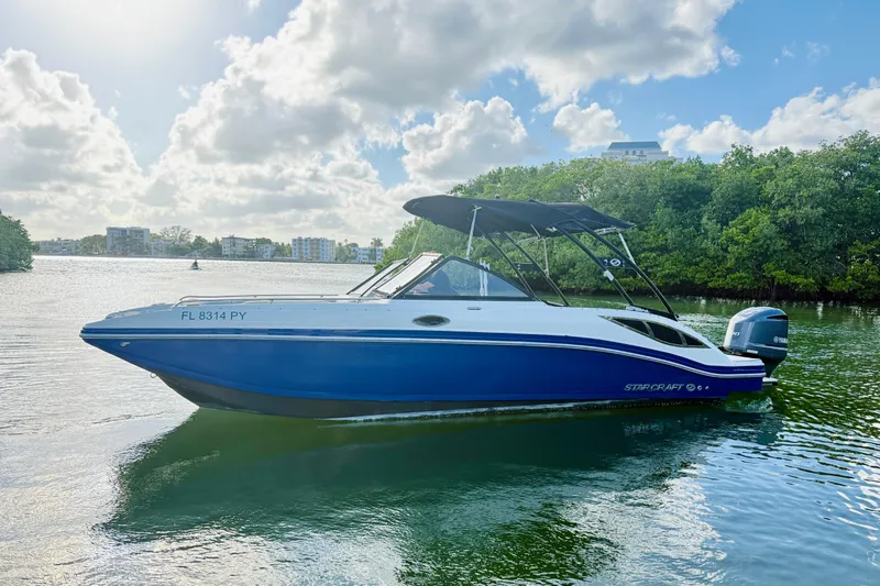 Slide: The Image of 2015 Starcraft Crossover 250 SCX OB boat on calm water, under a partly cloudy sky. - 36