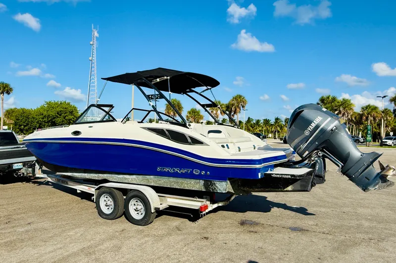 Slide: The Image of 2015 Starcraft Crossover 250 SCX OB boat on trailer, blue and white design, Yamaha outboard motor. - 4