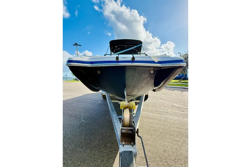 Slide: The Image of 2015 Starcraft Crossover 250 SCX OB boat on trailer under blue sky. - 6