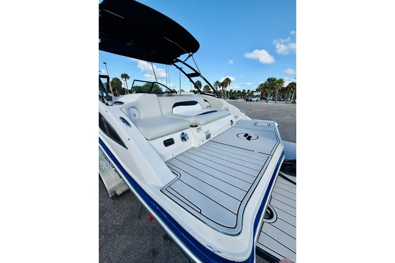 Slide: The Image of 2015 Starcraft Crossover 250 SCX OB boat with spacious deck and seating, under clear blue sky. - 8