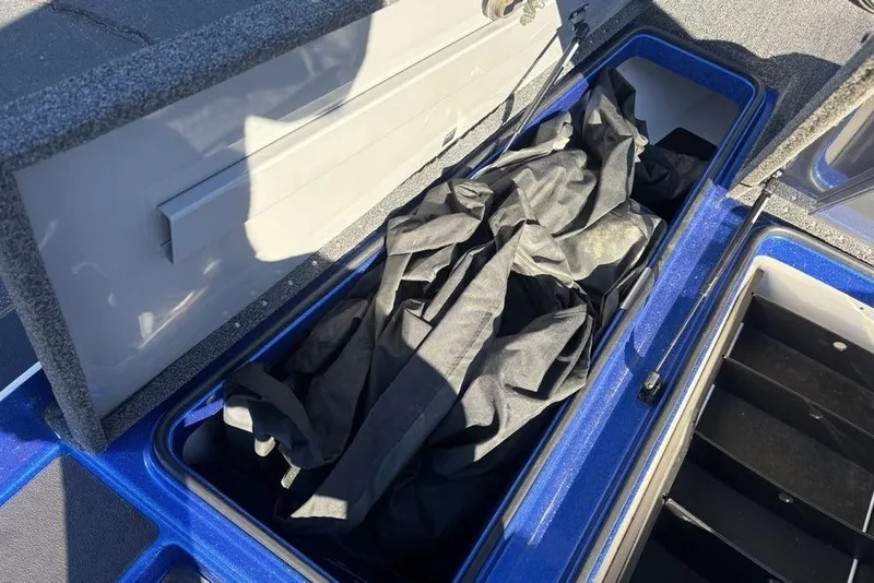 Slide: The Image of Open storage compartment in 2021 Caymas CX20 boat with black cover inside. - 11