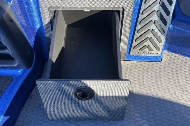 Slide: The Image of Open storage compartment in 2021 Caymas CX20 boat, featuring textured design and blue accents. - 16