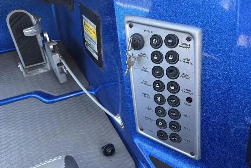 Slide: The Image of Control panel of a 2021 Caymas CX20 boat with various switches and key ignition. - 27