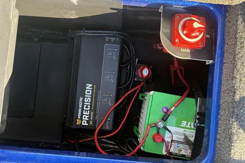 Slide: The Image of 2021 Caymas CX20 boat battery compartment with Minn Kota Precision charger and power switch. - 31