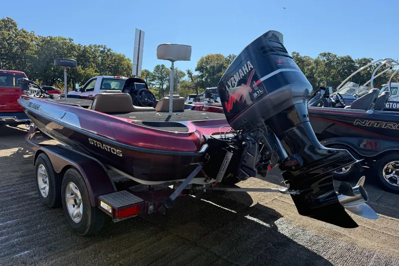 Slide: The Image of 2000 Stratos 20SS Extreme boat at lakeside dock with other boats and clear sky. - 17