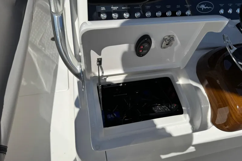 Slide: The Image of 2024 Valhalla V-29 Hybrid boat console with open storage compartment and control panel. - 12
