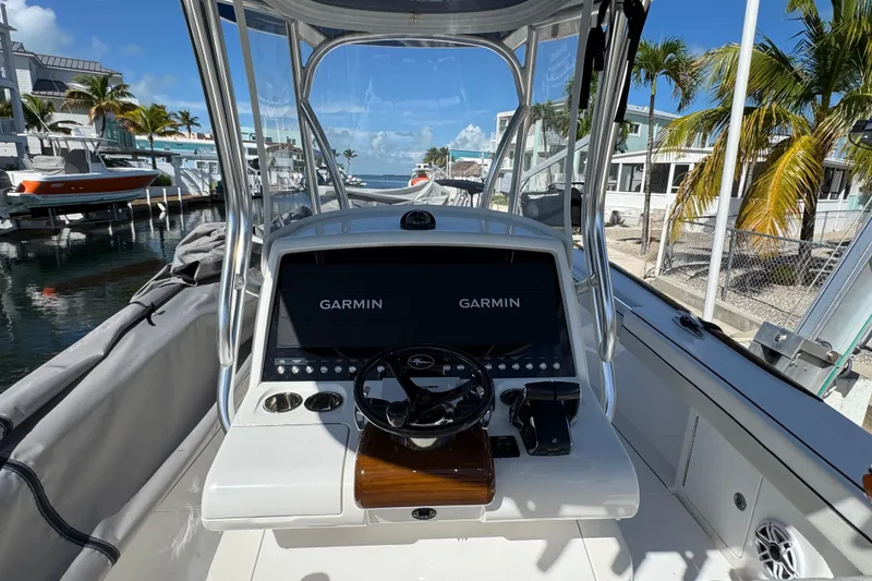 Slide: The Image of 2024 Valhalla V-29 Hybrid boat dashboard with Garmin displays, docked near palm trees. - 17
