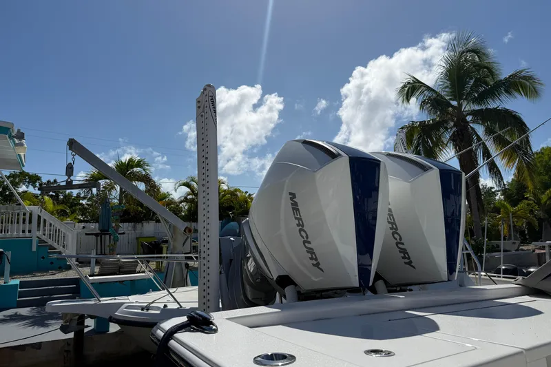 Slide: The Image of 2024 Valhalla V-29 Hybrid boat with twin Mercury engines, docked under a clear blue sky. - 5