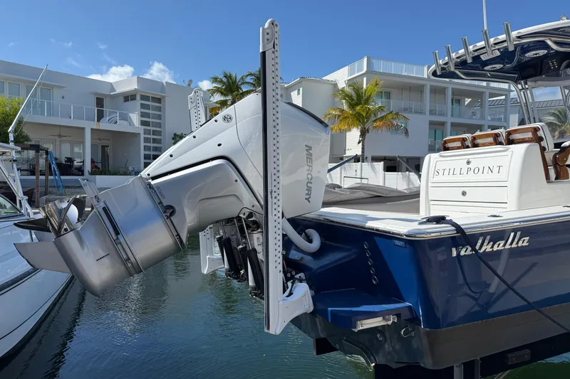 Slide: The Image of 2024 Valhalla V-29 Hybrid boat with Mercury engine, docked near modern waterfront homes. - 6