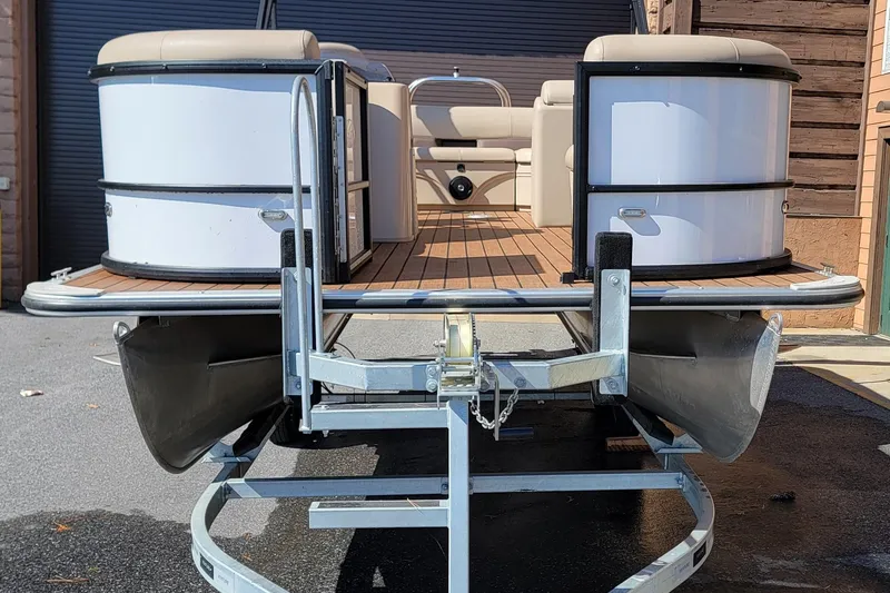 Slide: The Image of 2024 Bentley Pontoons Legacy Cruise pontoon boat on trailer, showcasing sleek design and spacious deck. - 5