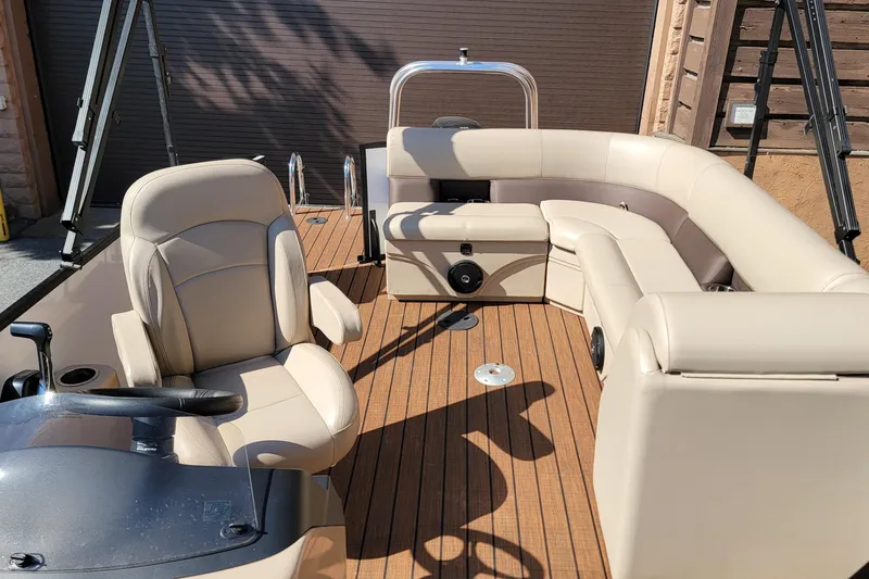 Slide: The Image of 2024 Bentley Pontoons Legacy Cruise interior with beige seating and wood flooring. - 7